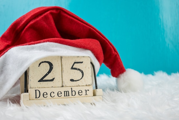 Foto tema del giorno di natale e decorazione con cappello santa.wood cubo presente calendario data 25 e mese di dicembre