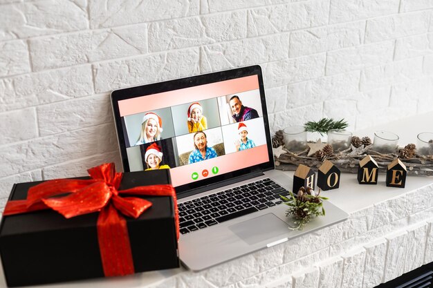 Christmas day virtual meeting team teleworking. family video\
call remote conference. laptop webcam screen view. diverse portrait\
headshots meet working from their home offices. happy hour party\
online