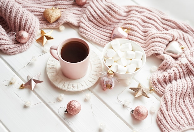 Christmas decor, balls, woolen plaid on the window , home comfort concept, seasonal winter celebrations. . Christmas pink cup with marshmallow.