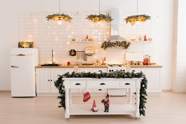 Christmas decor Bright white kitchen interior with bright garlands and Christmas wreaths