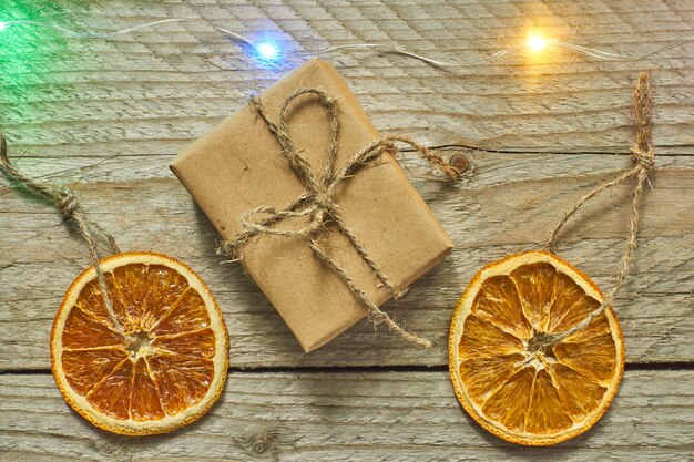 Christmas decor. Dried orange slice and gift box in craft paper , top view, minimal flat lay