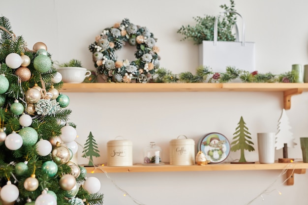 Photo christmas decor in kitchen. christmas tableware. christmas cooking utensils. bright interior of new year's cuisine. new year card template. white mint colors kitchen.