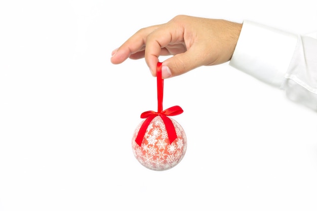 クリスマスの装飾と人々の概念、白い背景で隔離の赤いクリスマスボールを持っている男の手
