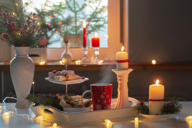 Christmas decor and red cups with hot drink on kitchen