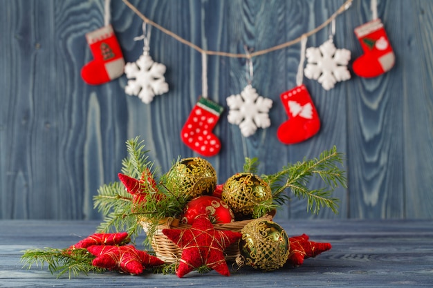 Christmas decor table. The branch of a Christmas tree, a pine cone, stars on a wooden wall.