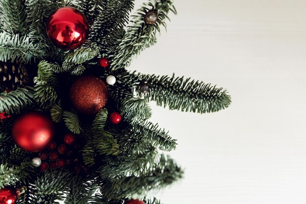 Foto decorazione natalizia con rami di pino e palle natalizie su uno sfondo bianco per un'iscrizione decorazione di capodanno