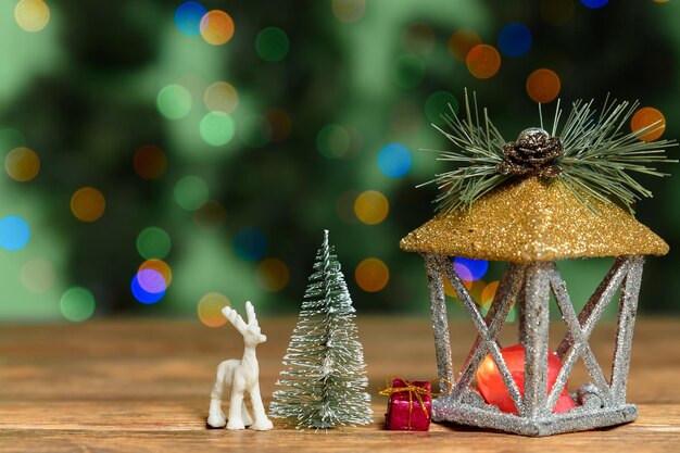 Christmas decor on wooden table against green background with blurred lights