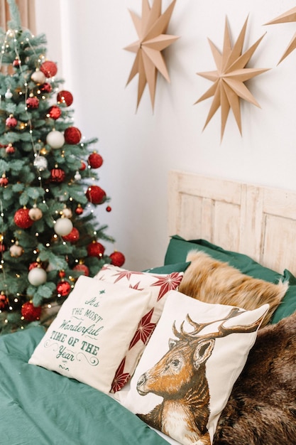 Christmas decorated bedroom in classic red and green colors. Green bed linen, red Christmas blanket