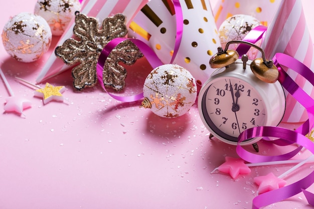 Christmas decoration and alarm clock in pink surface