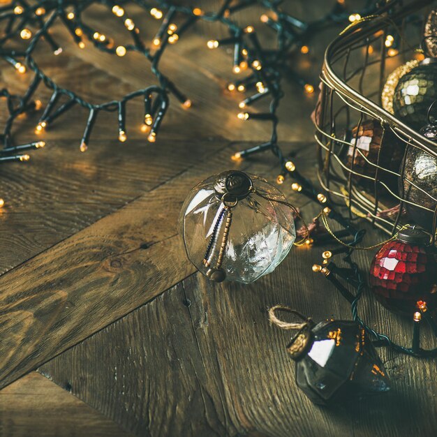 Christmas decoration balls in box and light garland square crop