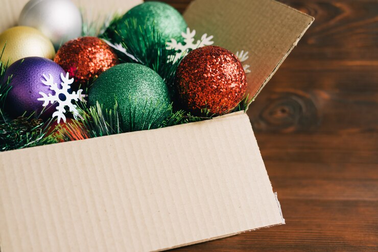 Photo christmas decoration in a cardboard box on a wooden background