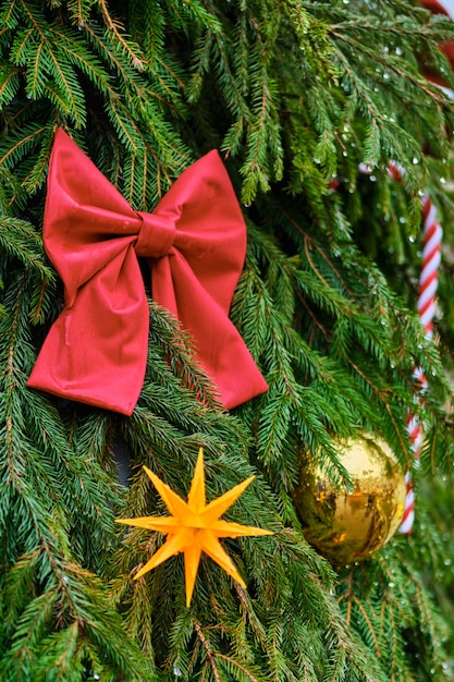 Christmas decoration in the form of a red bow with a yellow ball