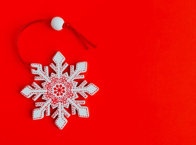 Christmas decoration in the form of a snowflake on a red background with space for text Christmas card template