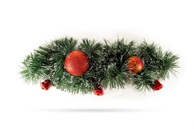 Christmas decoration garland of fir branches, red balls and bells. Winter holiday theme. Happy New Year. Space for text.