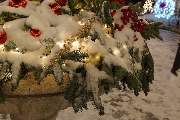 Christmas decoration and garlands covered with snow outside in winter.