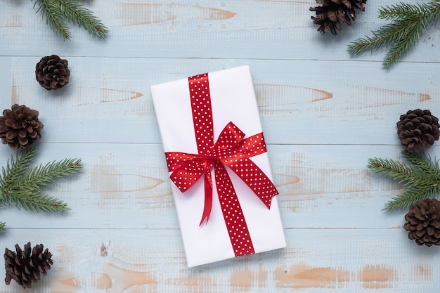 Christmas decoration, gift box and pine tree branches on wooden background