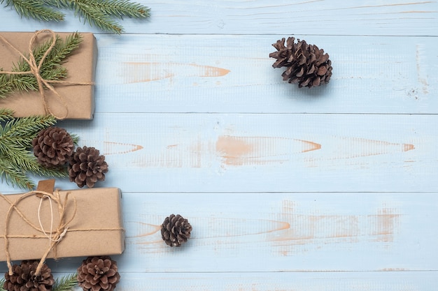 Новогоднее украшение, подарочная коробка и ветви сосны на деревянном фоне