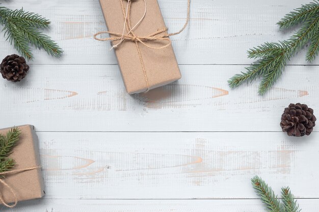 Christmas decoration, gift box and pine tree branches on wooden background