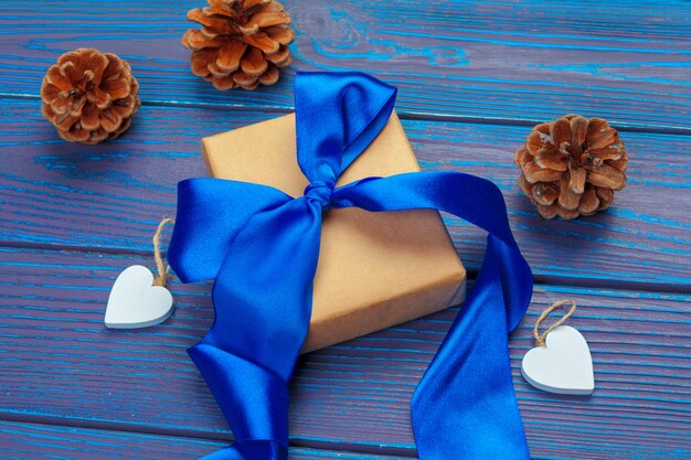 Christmas decoration, gift box and pine tree branches on wooden background