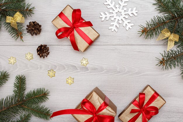 Christmas decoration. Gift boxes, fir tree branches with cones and christmas toys on gray wooden boards. Top view. Christmas greeting card concept.