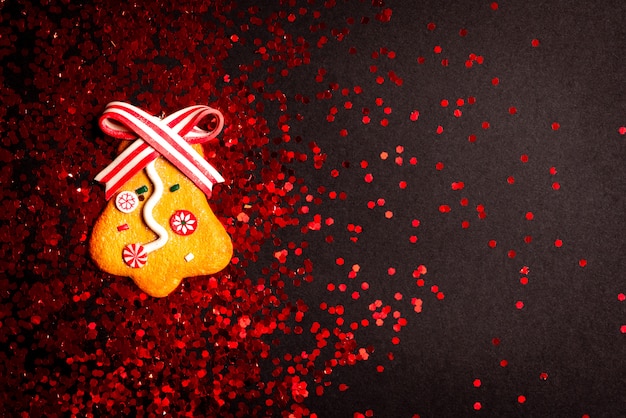 黒に赤のキラキラとジンジャーブレッドベルのクリスマスの装飾。上面図。 Copyspaceでフラットレイアウト