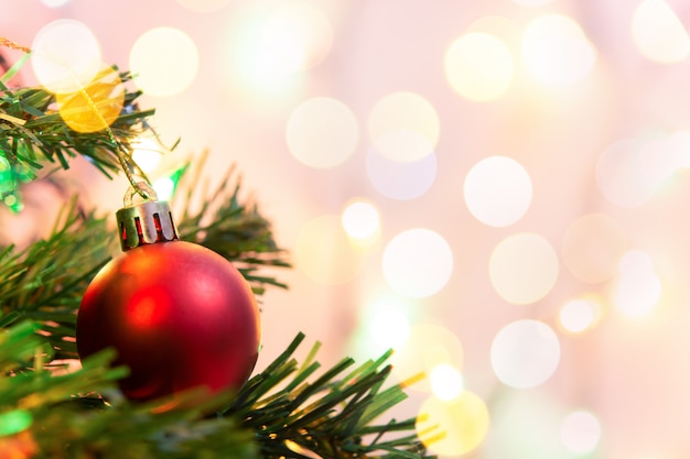 Christmas decoration. Hanging red balls on pine branches Christmas tree garland and ornaments over abstract bokeh with copy space