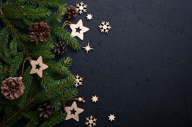Рождественские украшения. Праздничные украшения с шарами, еловыми ветками и подарком на темном черном фоне. Бордюрный дизайн. Вид сверху.