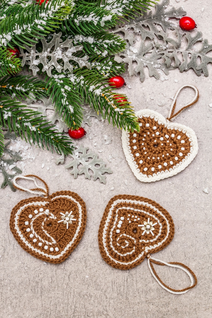 Photo christmas decoration. new year fir tree,  fresh leaves, crocheted ginger cookies hearts and artificial snow. 