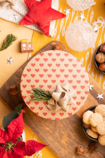 Фото Новогоднее украшение на столе. flatlay с крафтовой подарочной коробкой, пуансеттия, орехи, рождественские украшения