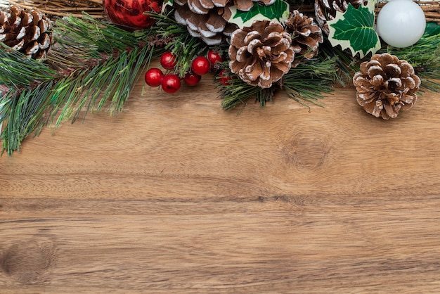 Christmas decoration pine branch in snow berries and pine cone on wooden