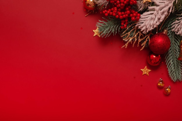コピー スペース新年グリーティング カード フラット レイアウトと赤の背景にクリスマスの装飾と松の木