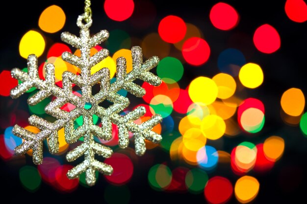 Christmas decoration snowflake on defocused lights background