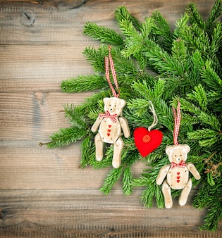 Decorazione natalizia. giocattoli in stile vintage orsacchiotto con ramoscelli sempreverdi su fondo in legno
