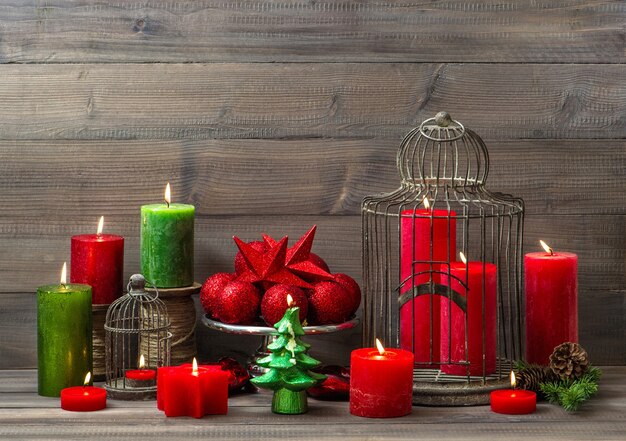 Christmas decoration with burning candles, baubles and birdcage. nostalgic home interior