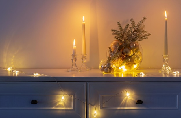 Christmas decoration with burning candles in white interior