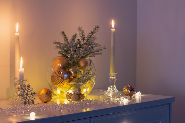 Christmas decoration with burning candles in white interior