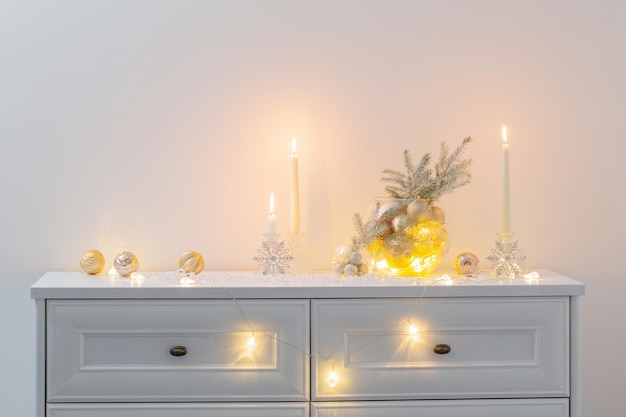 Christmas decoration with burning candles in white interior