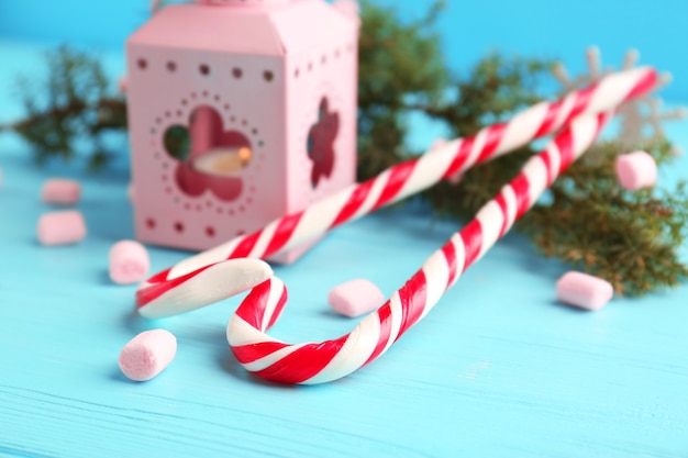 Christmas decoration with candy canes on blue wooden table