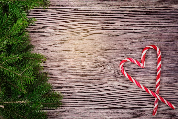 Foto decorazione di natale con la caramella su una priorità bassa di legno