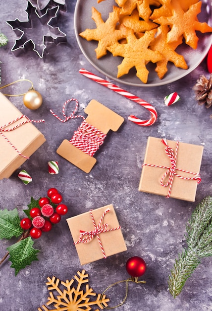 Christmas decoration with cones, cookies, gift boxes, red candles, candies. Top view.