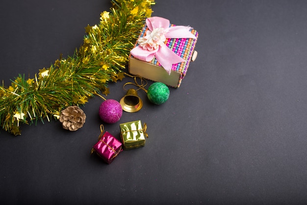 Christmas decoration with dark black background. top view, copy space. Ball, Gift box, Santa clause, Ribbon, Branch pine, bell. 