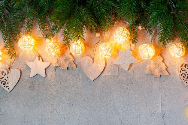 Photo christmas decoration with garland lights on concrete background