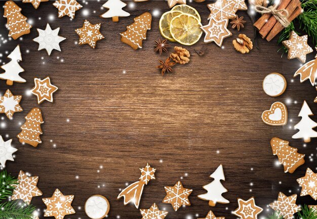 Christmas decoration with gingerbread cookies,christmas lights and spices on the old wooden board