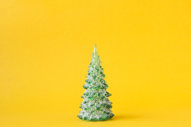 Christmas decoration with pine tree on yellow background.