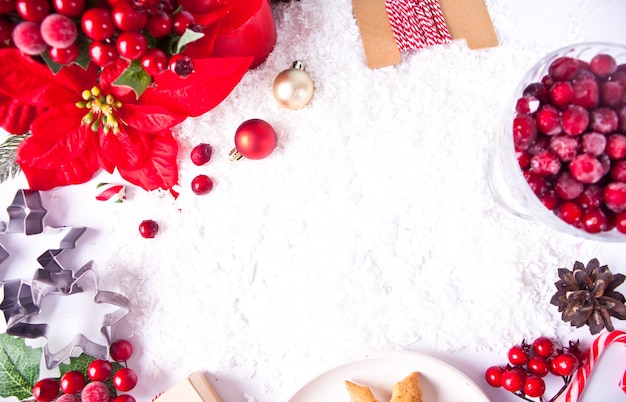 Christmas decoration with poinsettia flower, cranberries, cones, cookies. Top view. Copy space.