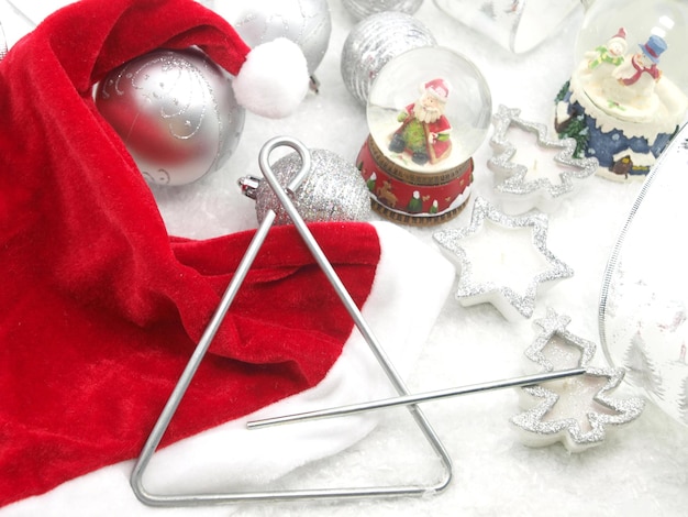 Photo a christmas decoration with a red santa hat and a metal triangle.