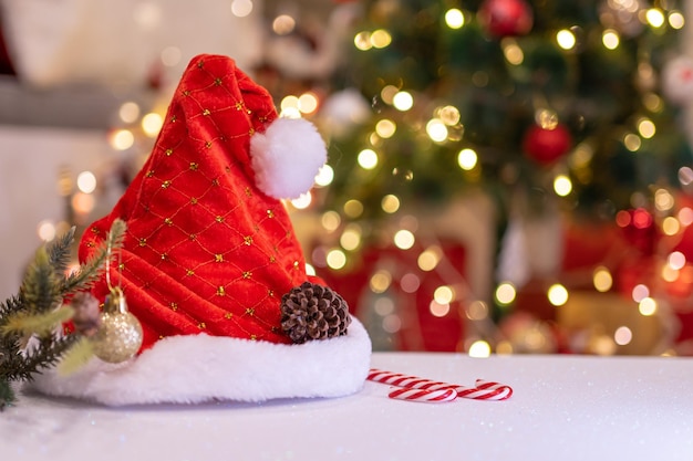 Foto decorazione natalizia con cappello e giocattolo di babbo natale. vacanza stagione invernale con sfondo bokeh chiaro.