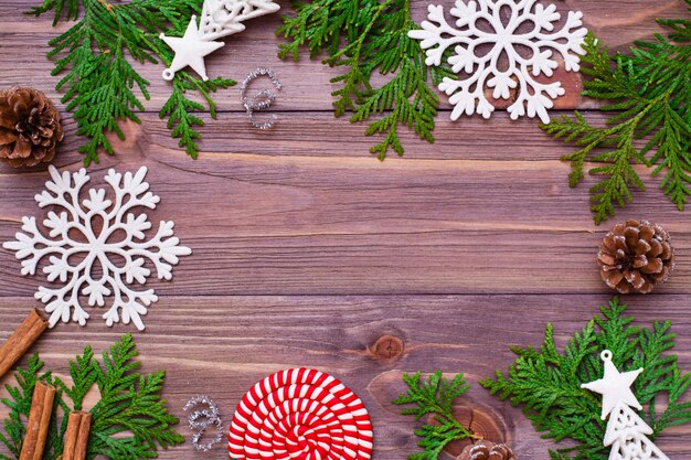 Christmas decoration with thuja branches, snowflakes, pine cones, cinnamon and candy