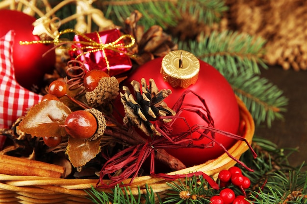 Christmas decorations in basket and spruce branches on table close up