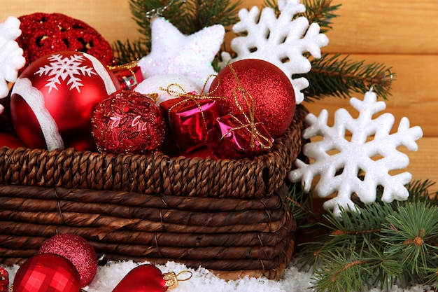 Christmas decorations in basket with snow on table